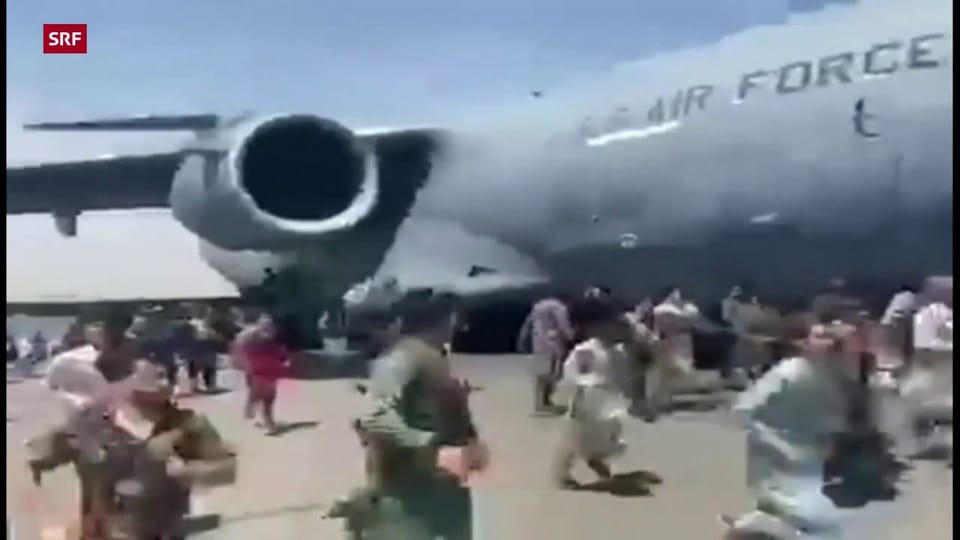 Menschen rennen Militärflugzeug hinterher