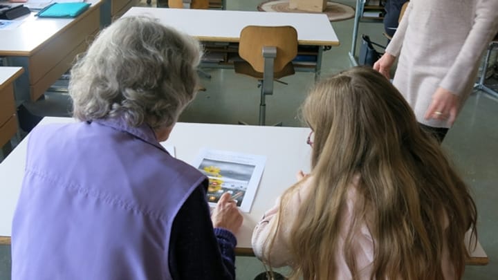 Schüler helfen Senioren beim Gebrauch von Tablets